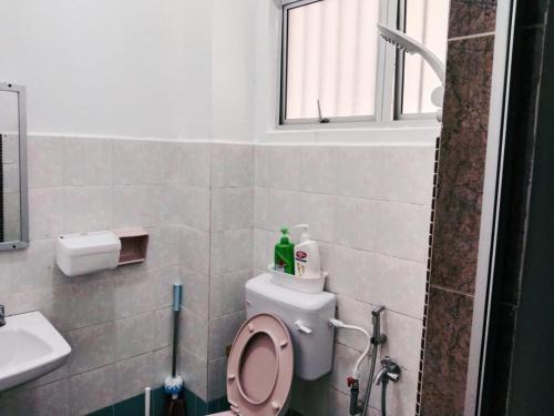 a bathroom with a toilet with a sink and a window at Area Indahpura or Taman Bersatu Kulai 3-4BR near AEON Airport JPO in Kulai