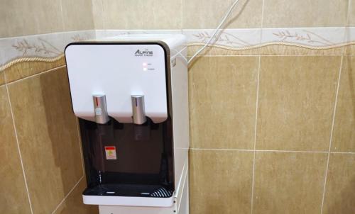 a paper towel dispenser on a wall in a bathroom at Area Indahpura or Taman Bersatu Kulai 3-4BR near AEON Airport JPO in Kulai