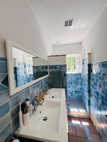La salle de bains est pourvue de 2 lavabos et de carrelage bleu. dans l'établissement Villa provençale, piscine, à Saint-Tropez
