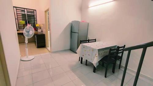 a dining room with a table and a refrigerator at Area Indahpura or Taman Bersatu Kulai 3-4BR near AEON Airport JPO in Kulai