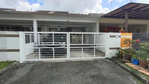 a white fence in front of a house at Area Indahpura or Taman Bersatu Kulai 3-4BR near AEON Airport JPO in Kulai