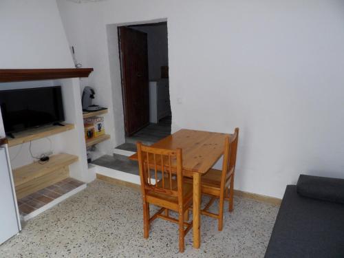 une table à manger avec deux chaises et une télévision dans l'établissement Studio chez Steph, à Eyguières