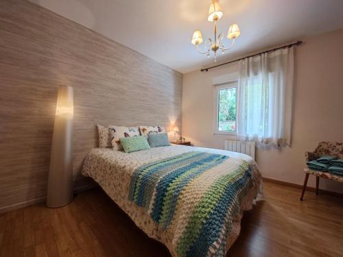 - une chambre avec un lit et une couverture colorée dans l'établissement ALOJAMIENTO MIRABUENOS, à Aranda de Duero