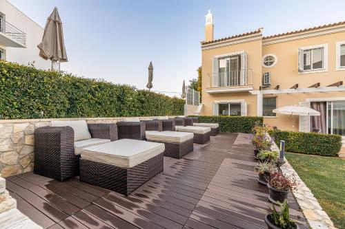 a patio with wicker furniture and an umbrella at Boutique & Villas Boliqueime in Boliqueime