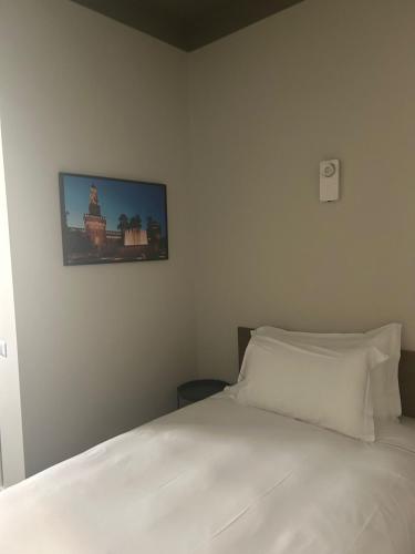 a bedroom with a white bed and a tv on the wall at Hotel 22 Marzo in Milan
