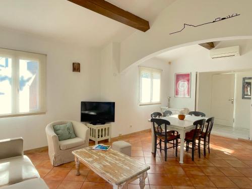 a living room with a table and a tv at Maison au calme avec jardin et parking, proche de tout ! in La Ciotat