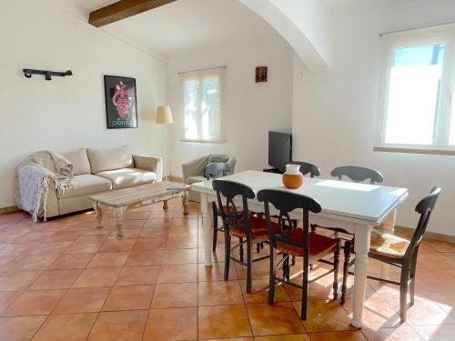 uma sala de estar com uma mesa branca e cadeiras em Maison au calme avec jardin et parking, proche de tout ! em La Ciotat