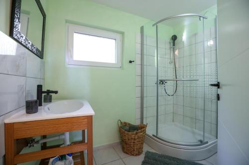 e bagno con doccia, lavandino e vasca. di Exceptional Apartment Juniper, FIRST ROW TO THE SEA a Božava