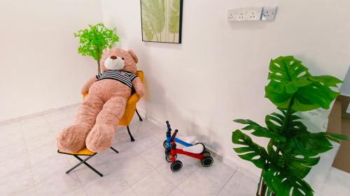 a teddy bear sitting on a chair next to a plant at Area Indahpura or Taman Bersatu Kulai 3-4BR near AEON Airport JPO in Kulai