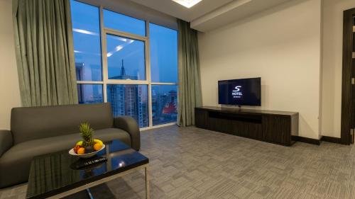 a living room with a couch and a television at S Hotel Bahrain in Manama
