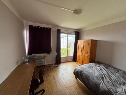 une chambre avec un lit, un bureau et une fenêtre dans l'établissement L'observatoire Toulousain, à Toulouse