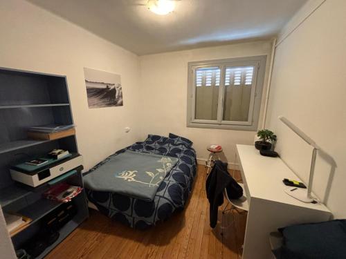 une chambre avec un lit et un bureau avec un ordinateur dans l'établissement L'observatoire Toulousain, à Toulouse