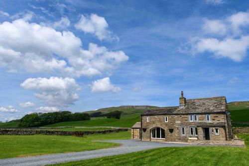 an old stone house in the middle of a field at Finest Retreats - Shepherds Cottage at Mile House Farm in Hawes