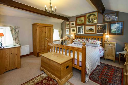 a bedroom with a bed with a wooden crib at Finest Retreats - Shepherds Cottage at Mile House Farm in Hawes