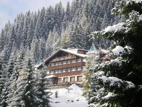 a large building on a snow covered mountain at Hotel Des Alpes in Soraga