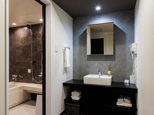 a bathroom with a sink and a shower at Reftel Osaka Airport Hotel in Ikeda