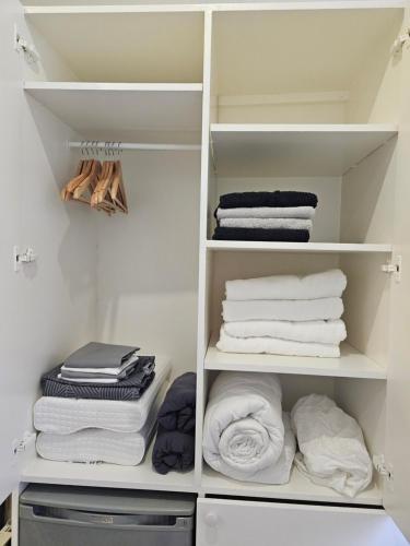 un placard avec des étagères blanches et des serviettes. dans l'établissement Studio Champs Elysées Tour Eiffel, à Paris