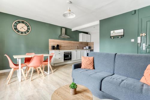 un salon avec un canapé bleu et une table dans l'établissement L'Émeraude de la Cité - Netflix - Fibre - Proche Cité - Clim, à Carcassonne