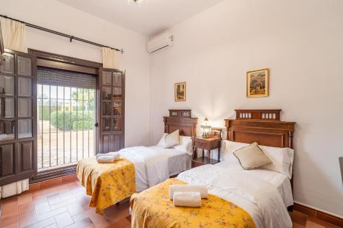 ein Schlafzimmer mit zwei Betten und einem Fenster in der Unterkunft Casa Rural Azahares de Marchena in Marchena