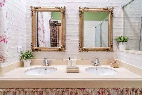 zwei Waschbecken im Bad mit zwei Spiegeln in der Unterkunft Casa Rural Azahares de Marchena in Marchena