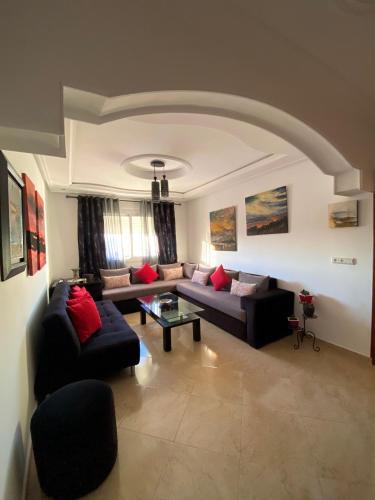 een woonkamer met banken en een salontafel bij Appartement près de la plage in Martil