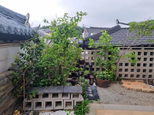 een tuin met bomen en planten in een gebouw bij Sarangroo in Jeonju