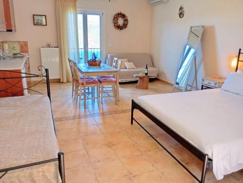 a living room with a bed and a table at Odysseion Apartments in Vathi, Ithaka