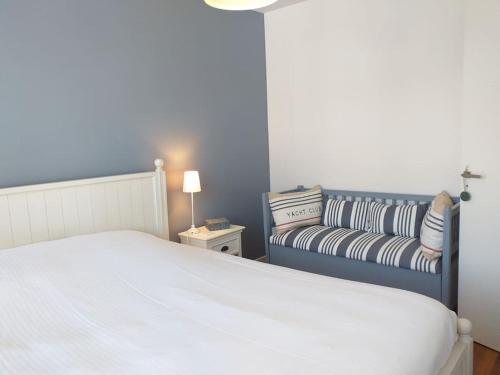 a bedroom with a bed and a couch at Le Plongeoir in Donville-les-Bains