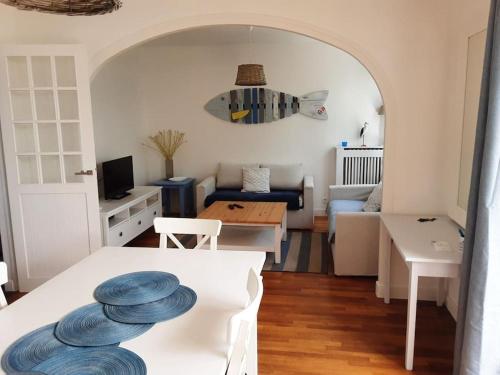 un salon avec une table avec des assiettes bleues dessus dans l'établissement Le Plongeoir, à Donville-les-Bains