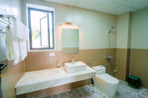 La salle de bains est pourvue d'un lavabo et de toilettes. dans l'établissement BAO AN RESORT & BUNGALOW, à Hòa Bình