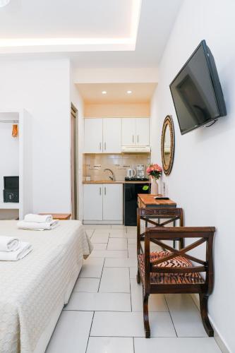 a room with a bed and a table and a tv at Georgia Pelekanou Studios in Fira