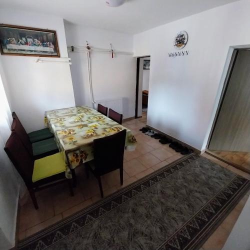 a dining room with a table and chairs in a room at CASA ANDREEA in Novaci-Străini