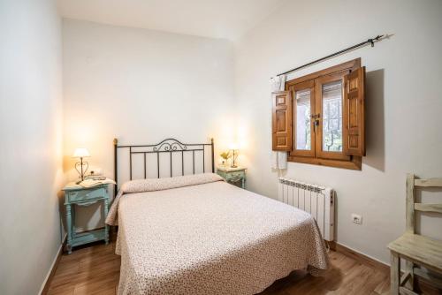a small bedroom with a bed and a window at Caserio del Colmenar in Huétor Santillán