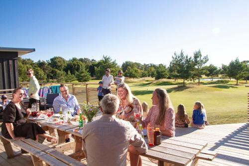 a group of people sitting around a picnic table at Halmstad Golfarena stugor in Halmstad