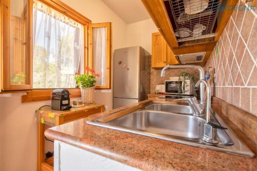 A kitchen or kitchenette at Alghero Villa Barranch with sea view swimming pool for 6 people
