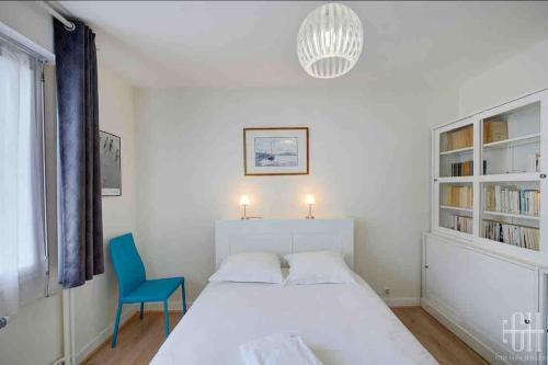 une chambre avec un lit blanc et une chaise bleue dans l'établissement Le Jasmin / Proche Gare, à Tours