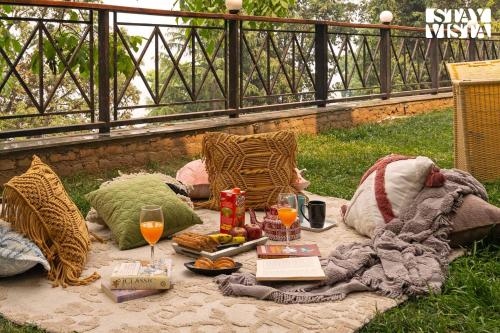 a picnic with a blanket and glasses of wine at StayVista at Barkat Villa with Jacuzzi in Rāmgarh