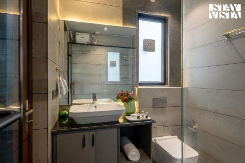 a bathroom with a sink and a toilet at StayVista at Barkat Villa with Jacuzzi in Rāmgarh