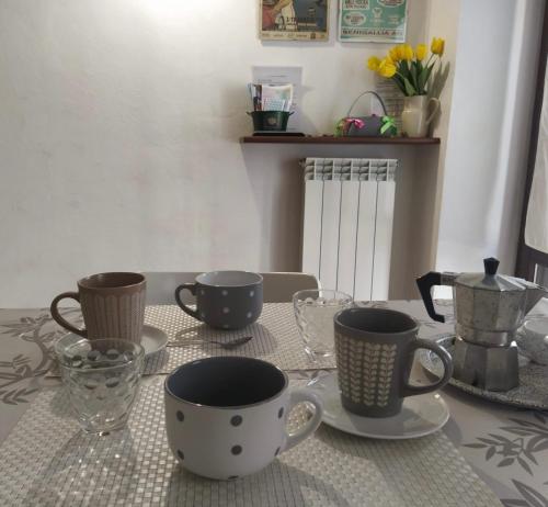 a table with cups and saucers on a table at Casa Lambertina in Senigallia