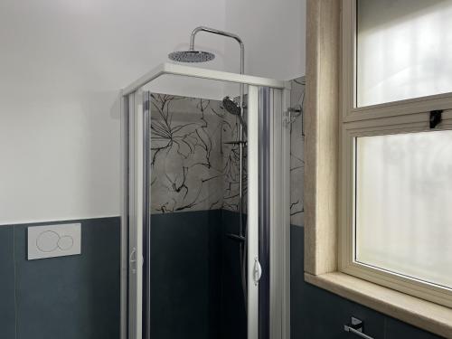 a shower with a glass door in a bathroom at Villetta Greco - Torre Lapillo in Porto Cesareo