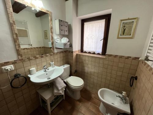 a bathroom with a toilet and a sink and a mirror at Casa Lambertina in Senigallia