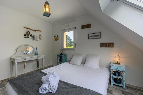 une chambre avec un lit avec des serviettes dessus dans l'établissement Nid sablé - Maison avec jardin à 700m de la plage, à Sarzeau