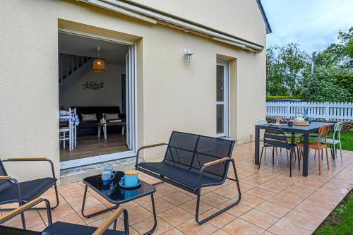 un patio avec des chaises et une table ainsi qu'une salle à manger dans l'établissement Nid sablé - Maison avec jardin à 700m de la plage, à Sarzeau