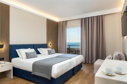 a hotel room with a bed and a view of the ocean at Palatino Hotel in Zakynthos Town