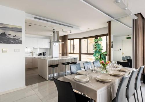 a dining room with a table and chairs and a kitchen at Seaview Luxury Haven Living & 3Bedrooms Seafront in Sliema