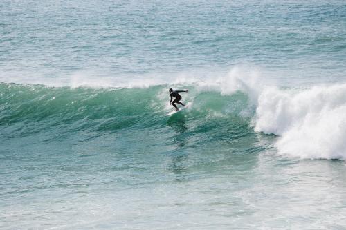 a man riding a wave on a surfboard in the ocean at Dar Maktoub in Agadir