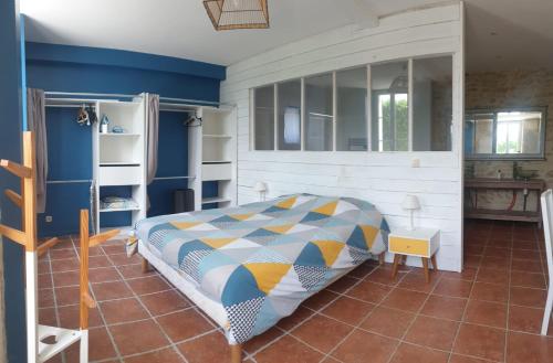 une chambre avec un lit et un mur bleu dans l'établissement Maison de charme avec suite parentale et grande piscine extérieure, à Anglade