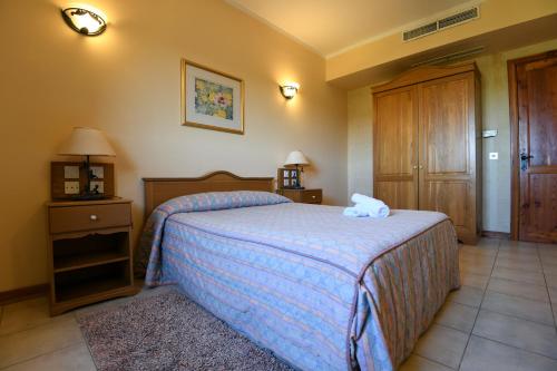 een slaapkamer met een bed met een handdoek erop bij Cornucopia Hotel in Xagħra