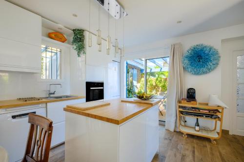 une cuisine avec des armoires blanches et un comptoir en bois dans l'établissement Villa 3 chambres - jardin privé, à Tourrettes-sur-Loup