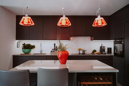 a kitchen with black cabinets and orange lights at Villa Dolce Vista in Gardone Riviera